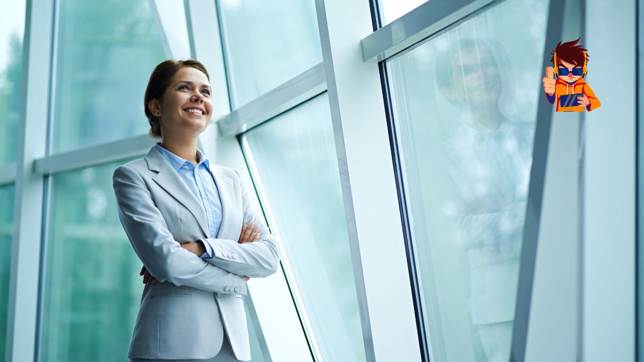 How to Stay Inspired While Managing a Busy Schedule A confident businesswoman in a light gray suit stands by a large glass window with her arms crossed, smiling as she looks ahead. The modern office setting reflects her professional and optimistic demeanor.