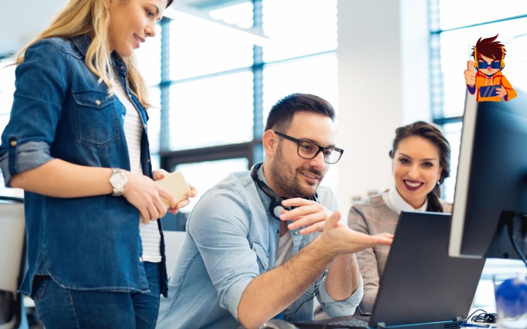 Group of three young professionals collaborating in front of a computer in a modern office.
